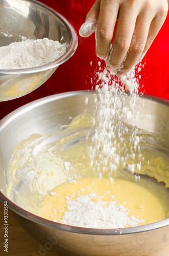 Pouring the flour into the mixture,making bakery