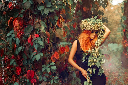 portrait of redhead young girl with wreath of hop on head outdoo