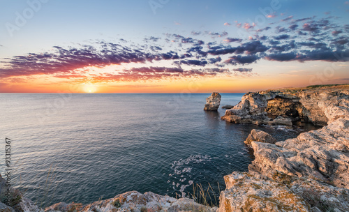 Beautiful seascape. Sea and rock at the sunrise. Nature composit photo