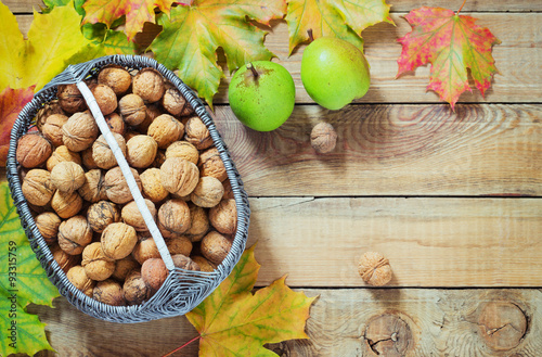 Autumn leaves walnuts over old wooden background photo