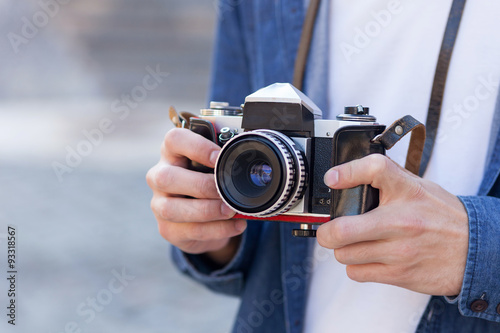 Cheerful young male tourist is making photos