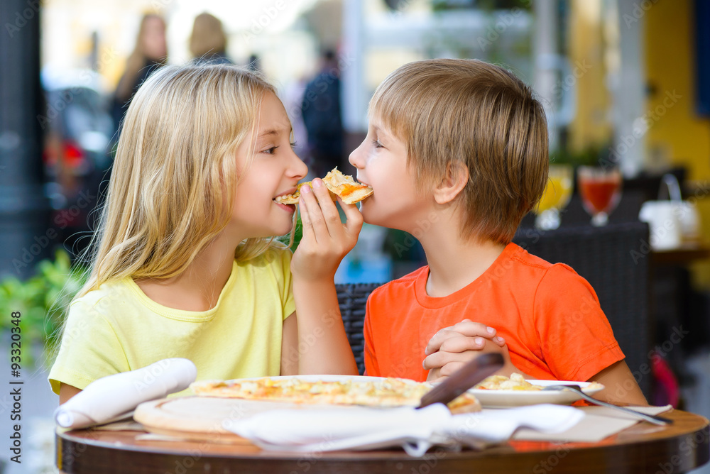 Happy children indoors eating pizza smiling Happy children indoors eating pizza smiling