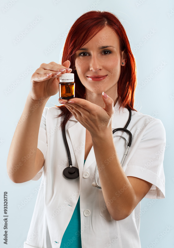 Young female doctor holding a bottle with pills in her hands Young female doctor holding a bottle with pills in her hands