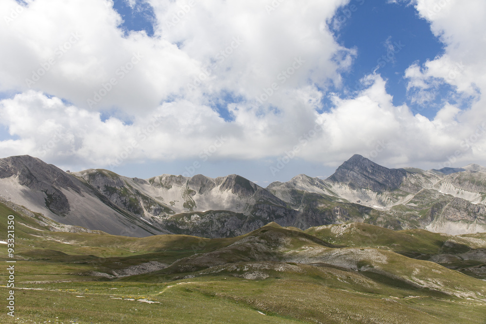 Panorama montano. Catena montuosa degli Appennini, Italia. Grandi nuvole bianche nel cielo blu