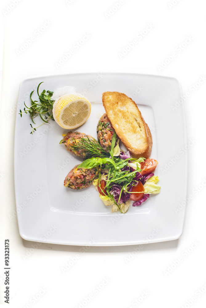 Salmon salad with vegetables and baguette on white background