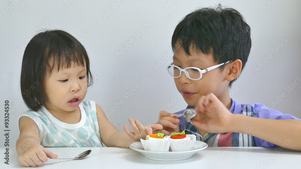 Asian siblings eating cake together in living room
Asian siblings eating cake together in living room