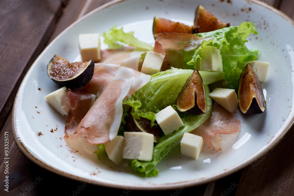 Salad with ham, cheese and figs, selective focus, close-up