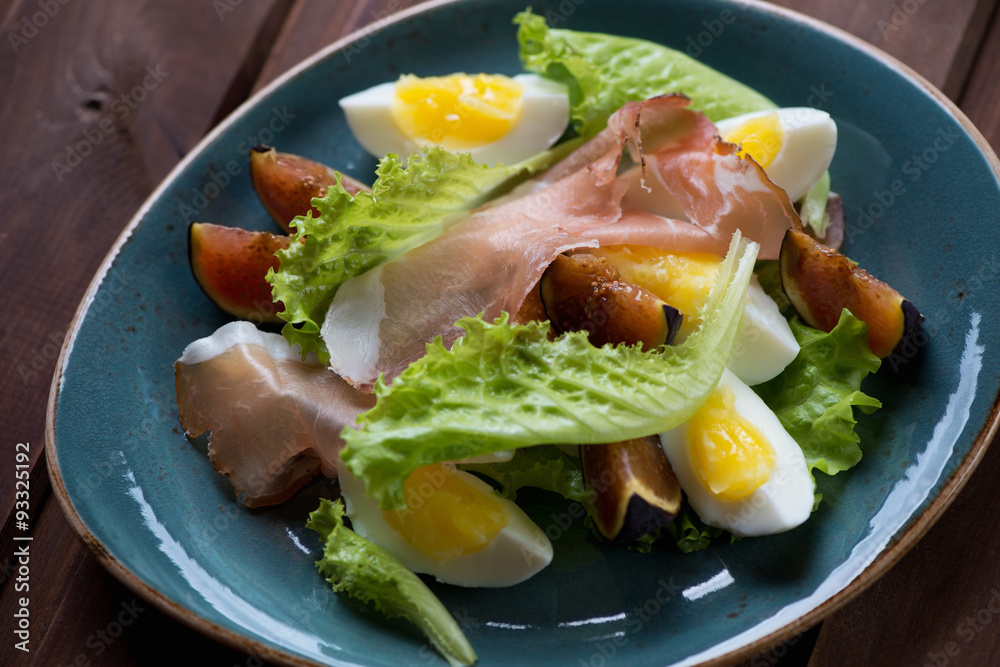 Salad with fresh fig fruits, ham and eggs. Close-up, top view Salad with fresh fig fruits, ham and eggs. Close-up, top view