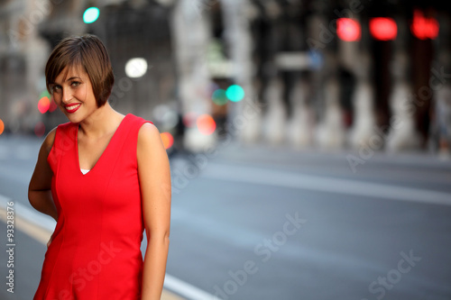 Smiling girl with red dress in urban background