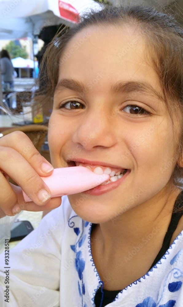 Fototapeta premium Niña sonriendo comiendo gominola