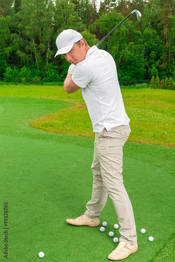 young man swings to strike a golf club young man swings to strike a golf club