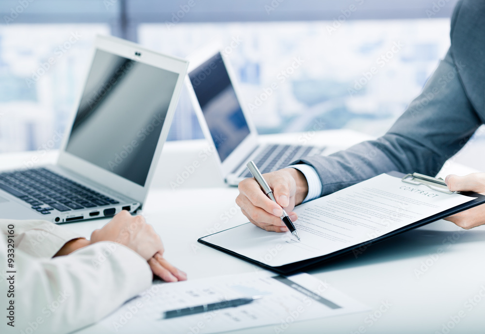 © Nonwarit - Female hand signing contract.