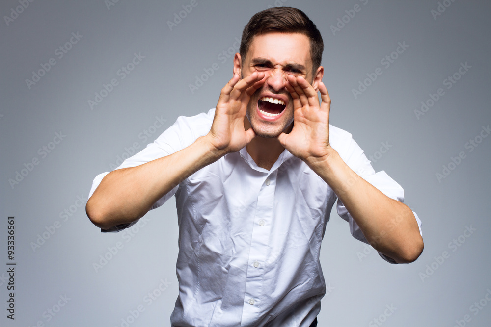 Businessman shouting over gray background. Businessman shouting over gray background.