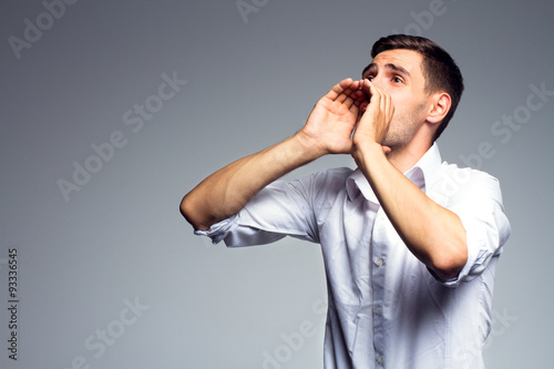 Fotografie Businessman shouting over gray background.