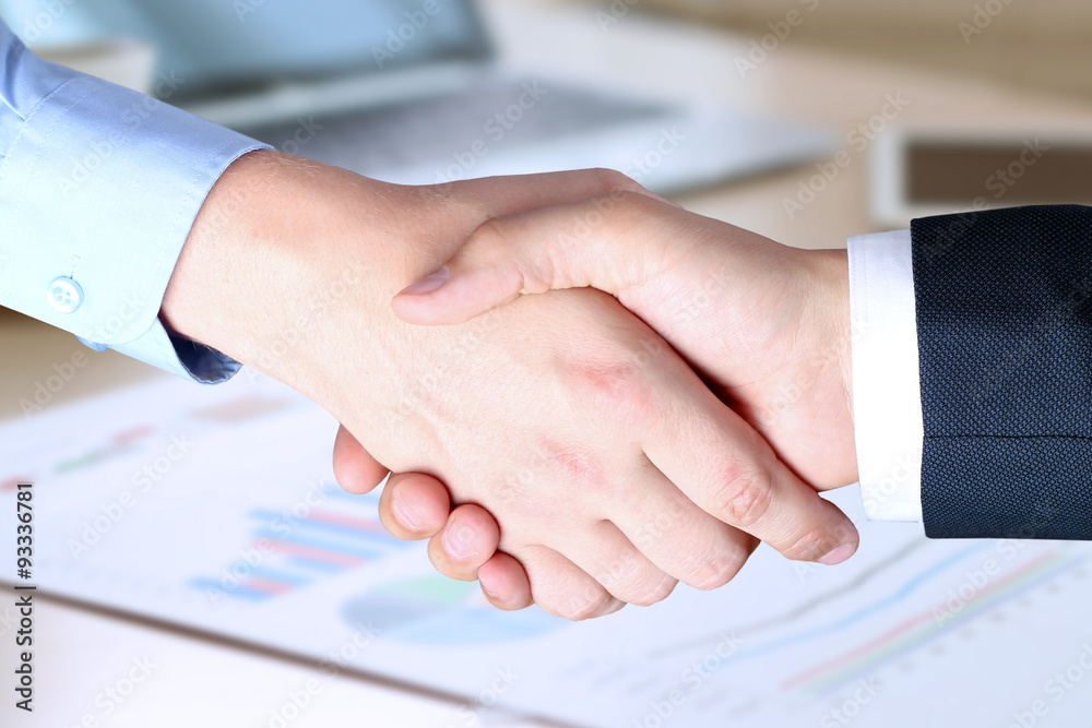 The Close-up image of a firm handshake between two colleagues in The Close-up image of a firm handshake between two colleagues in