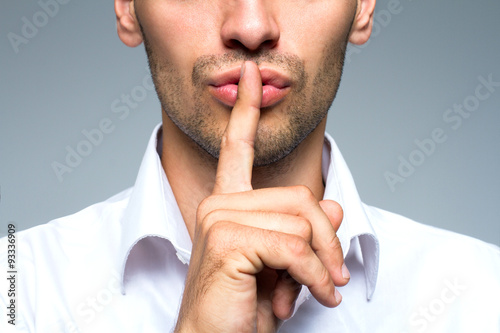 Businessman silent quiet gesture with finger