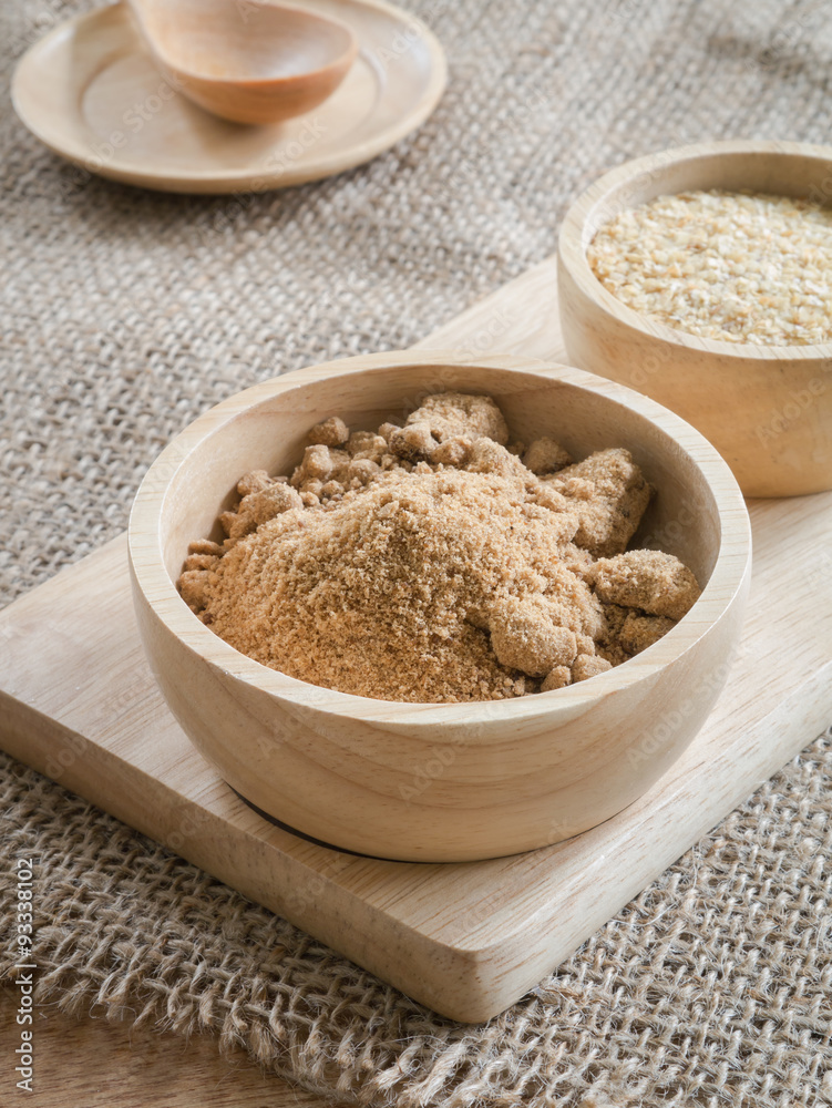 Brown sugar and wheat germ in wooden bowl Brown sugar and wheat germ in wooden bowl