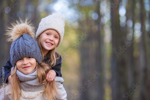 Fotografi Little adorable girls at warm sunny autumn day in the forest