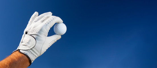 Acrylglasbilder Golf Hand mit Golfhandschuh hält Ball  © rcaucino
