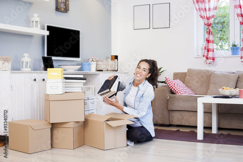 Woman unpacking cardboard boxes moving to new house
