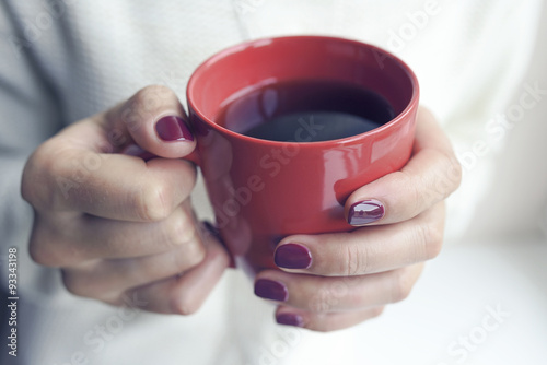 Cup of tea or coffee in female hands.