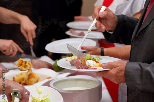 Chef serves portions of food at a party  