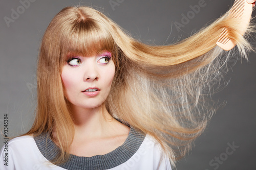Blonde woman with her damaged dry hair.