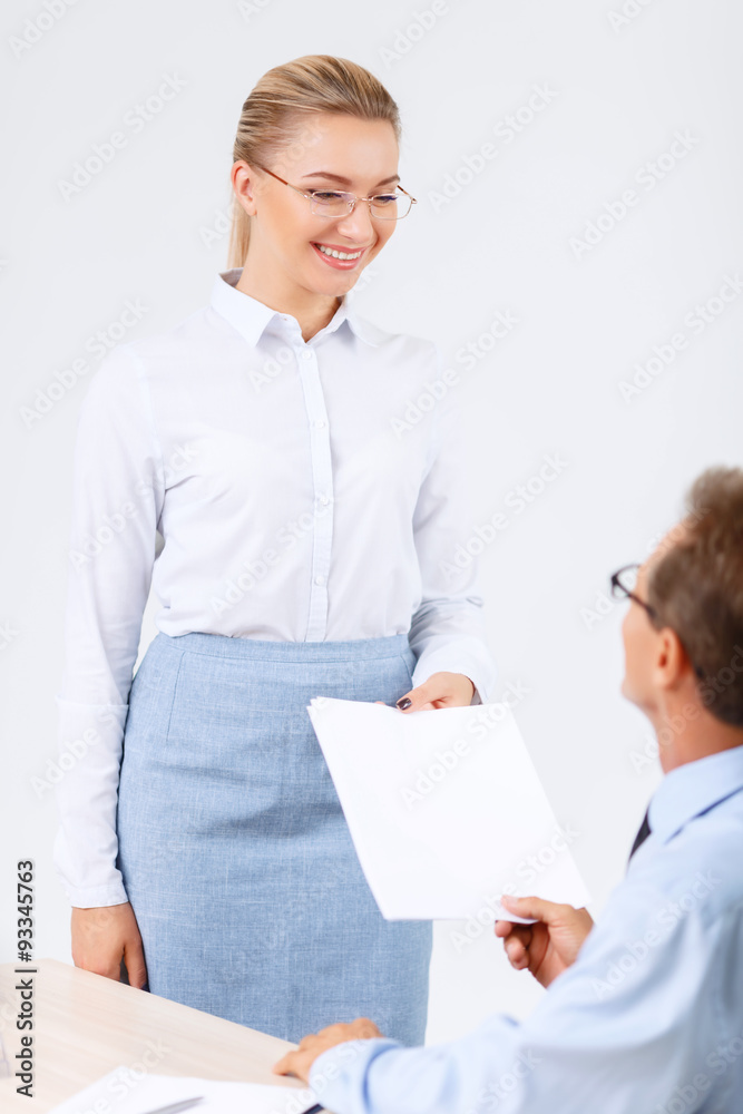 Professional lawyer giving papers to his assistant Professional lawyer giving papers to his assistant