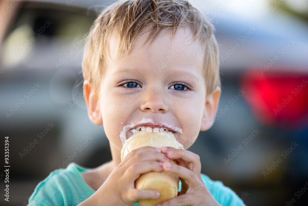 Cute little boy eating ice-cream and smiling Cute little boy eating ice-cream and smiling