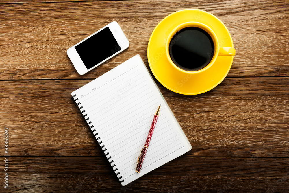 Workplace with phone,notebook, pen and cup of coffee on work tab Workplace with phone,notebook, pen and cup of coffee on work tab