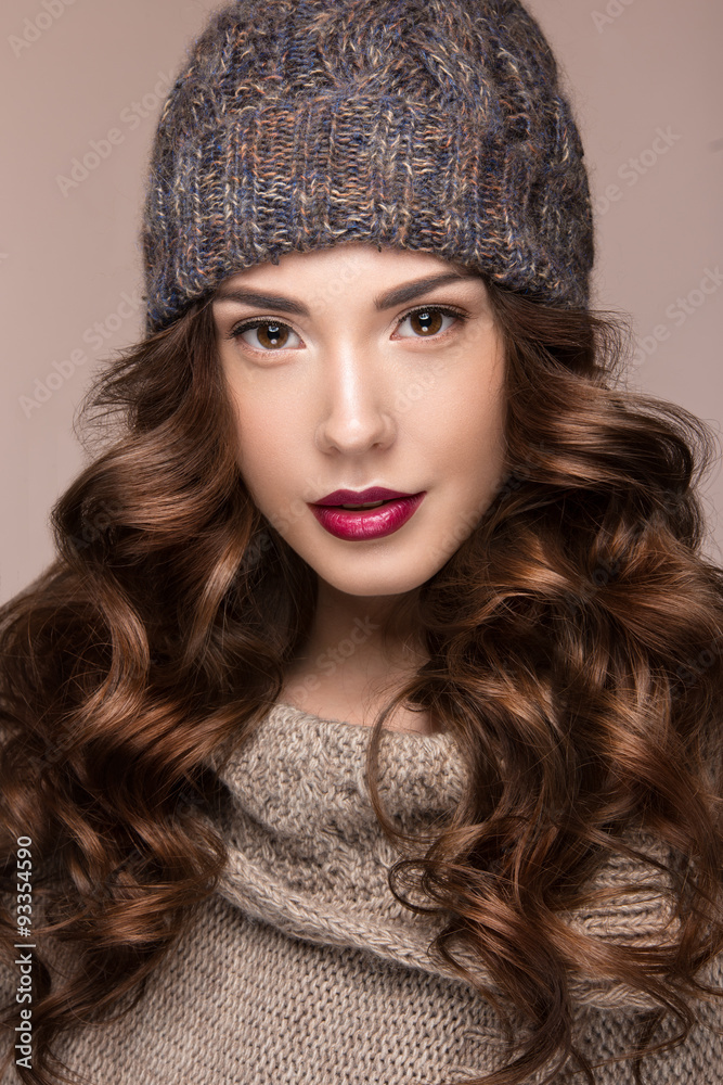 Beautiful girl with gentle makeup, curls in brown knit hat. Warm Beautiful girl with gentle makeup, curls in brown knit hat. Warm