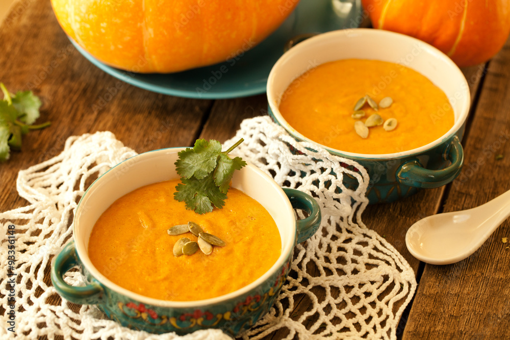 Traditional pumpkin soup on lace doily and wooden table Traditional pumpkin soup on lace doily and wooden table