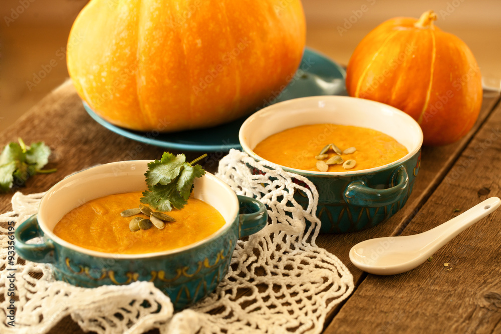 Traditional pumpkin soup on lace doily and wooden table Traditional pumpkin soup on lace doily and wooden table
