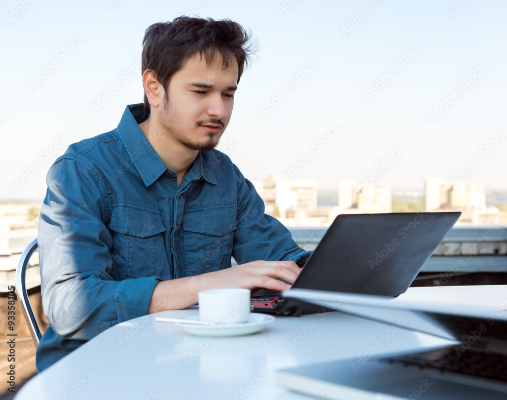 Young Asian Bearded Businessman Working on Computer at White Office Desk with Urban Landscape on Background Casual Clothing Young Asian Bearded Businessman Working on Computer at White Office Desk with Urban Landscape on Background Casual Clothing