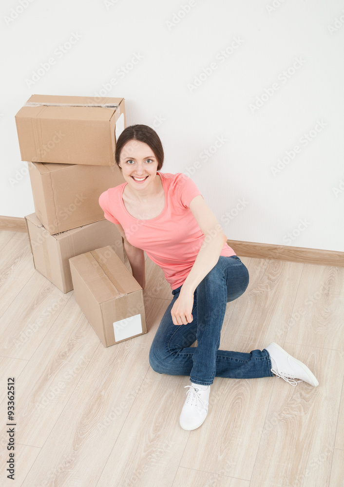 Happy young woman sitting on the floor Happy young woman sitting on the floor