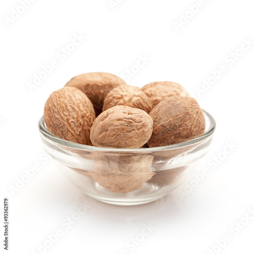Front view of Organic Nutmeg Seed or Jaiphal (Myristica fragrans) in glass bowl isolated on white background.