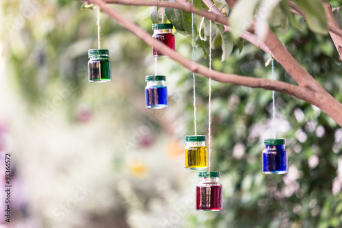 colorful water in small bottle hanging under the tree
