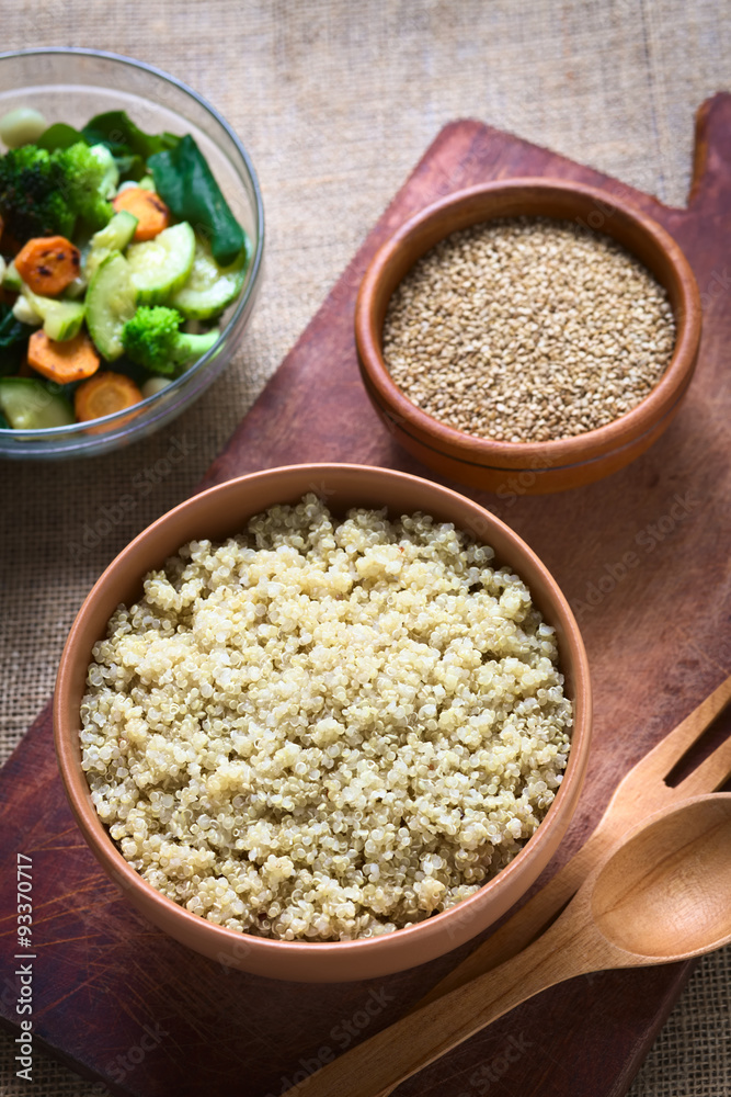 Cooked white quinoa seeds in bowl with sesame and fried vegetables in the back photographed with natural light (Selective Focus, Focus on the quinoa) Cooked white quinoa seeds in bowl with sesame and fried vegetables in the back photographed with natural light (Selective Focus, Focus on the quinoa)