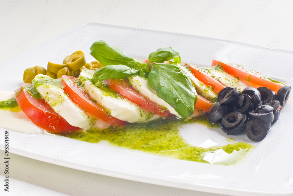 Caprese salad with tomato and mozzarella on white background