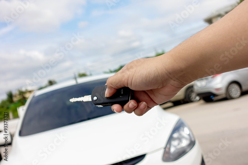 Female sitting in car showing key at the car parking