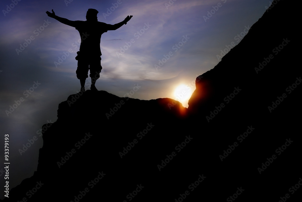  man on top of the mountain reaches for the sun