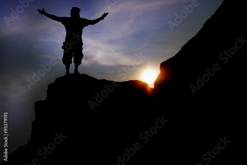  man on top of the mountain reaches for the sun