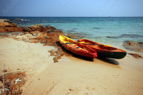  Red yellow kayaks on the tropical beach.