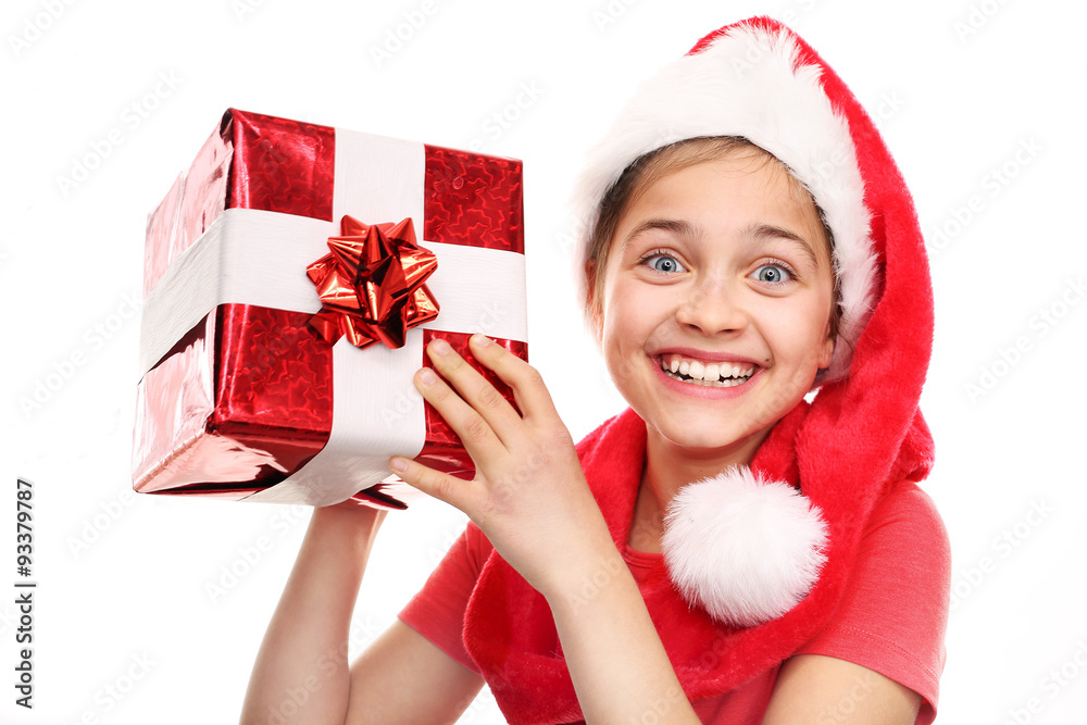 Świąteczne marzenia, Magiczny czas świąt. Szczęśliwe dziecko w czapce św. Mikołaja z zapakowanym prezentem - obrazy, fototapety, plakaty 