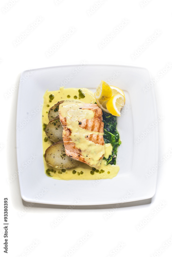 Grilled salmon with fried potatoes, spinach and butter sauce