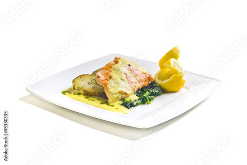 Obraz na płótnie Grilled salmon with fried potatoes, spinach and butter sauce w salonie