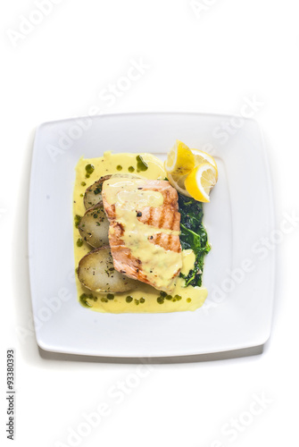 Obraz na płótnie Grilled salmon with fried potatoes, spinach and butter sauce w salonie