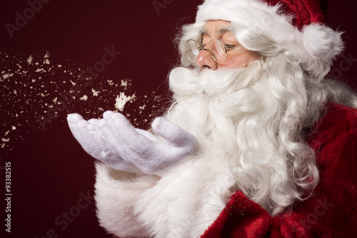 Santa claus blowing some snowflakes