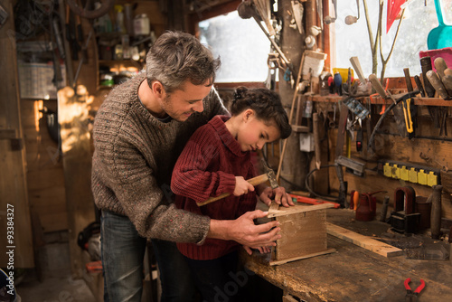 father and his little girl working a rustic wooden workshop 