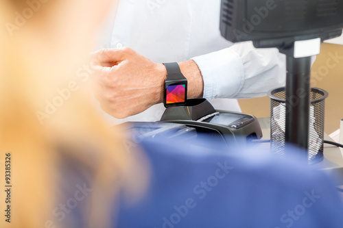 Midsection Of Customer Paying Through Smartwatch In Pharmacy